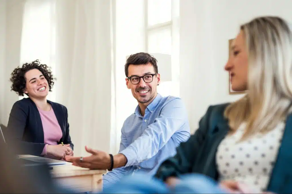 A man and two women having a conversation
