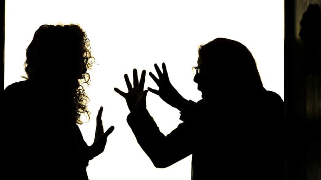 Silhouetted figures engage in a heated argument.