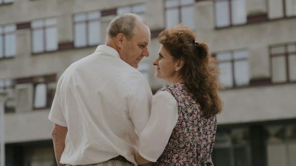 A man and a woman standing next to each other in front of a building.
