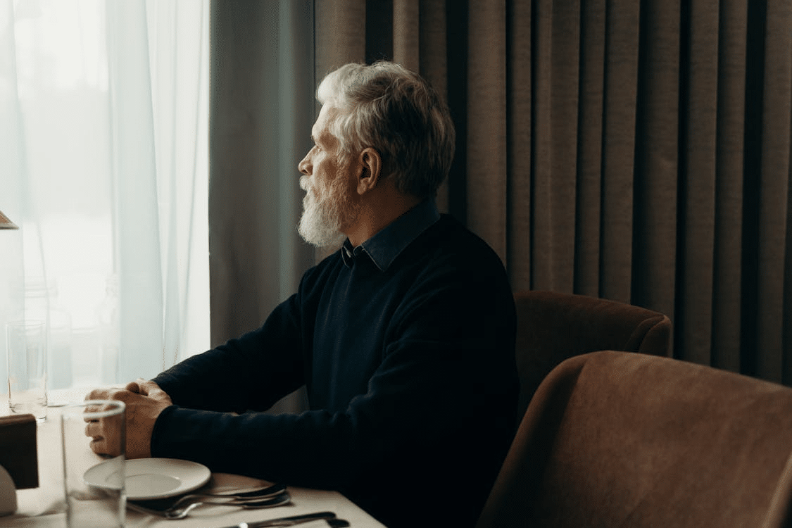 An older man alone and thinking at the table