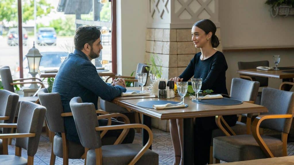 A couple sitting across from each other at a restaurant table.