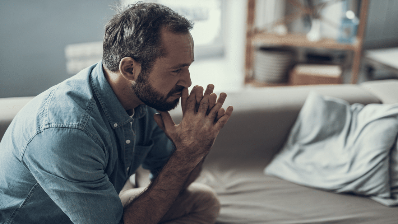 A man looking sad and thoughtful at home