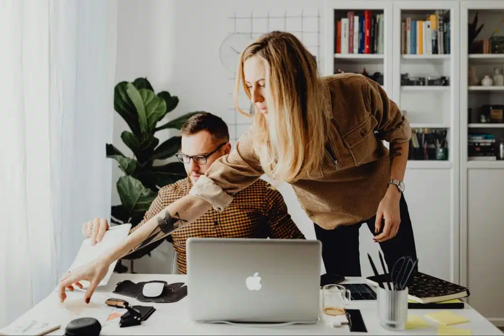 A woman checking man's workspace