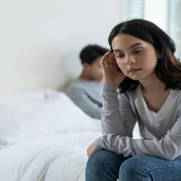 A woman looking sad in the bedroom