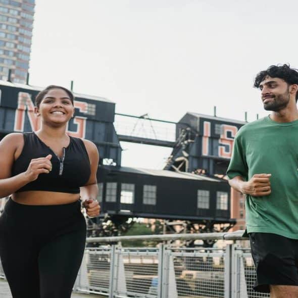 Couple running while the man looks at the woman