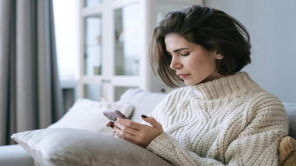 A woman looking sad while texting