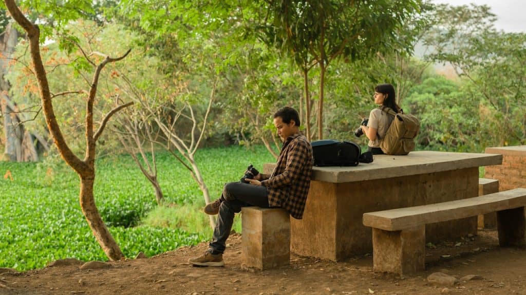 A couple of people sitting on top of a cement bench.