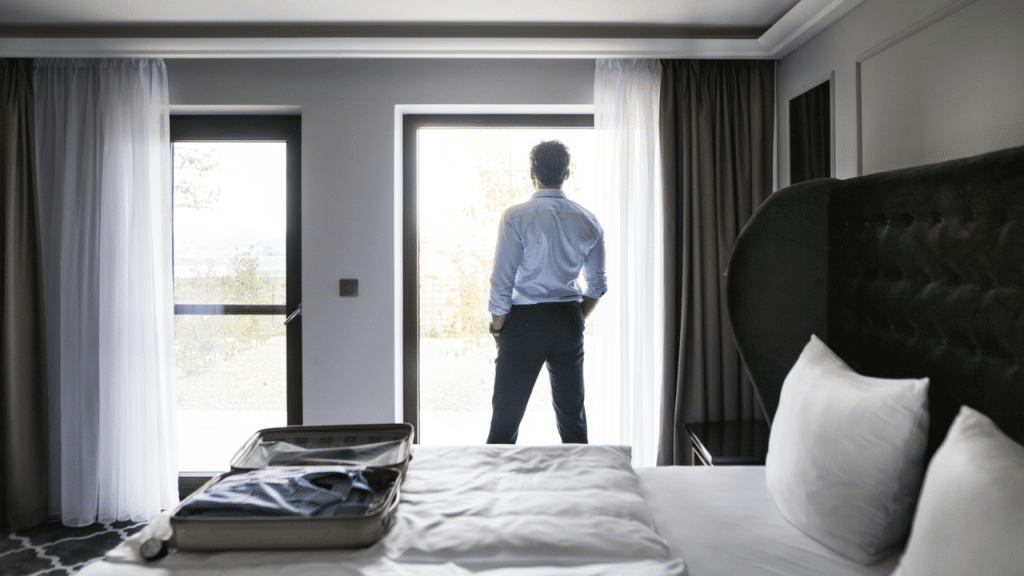 A man looking out the window at a hotel