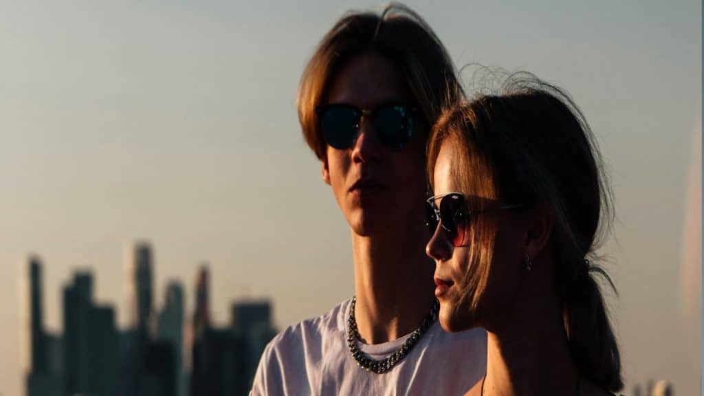 A young man and a woman standing on a ledge.