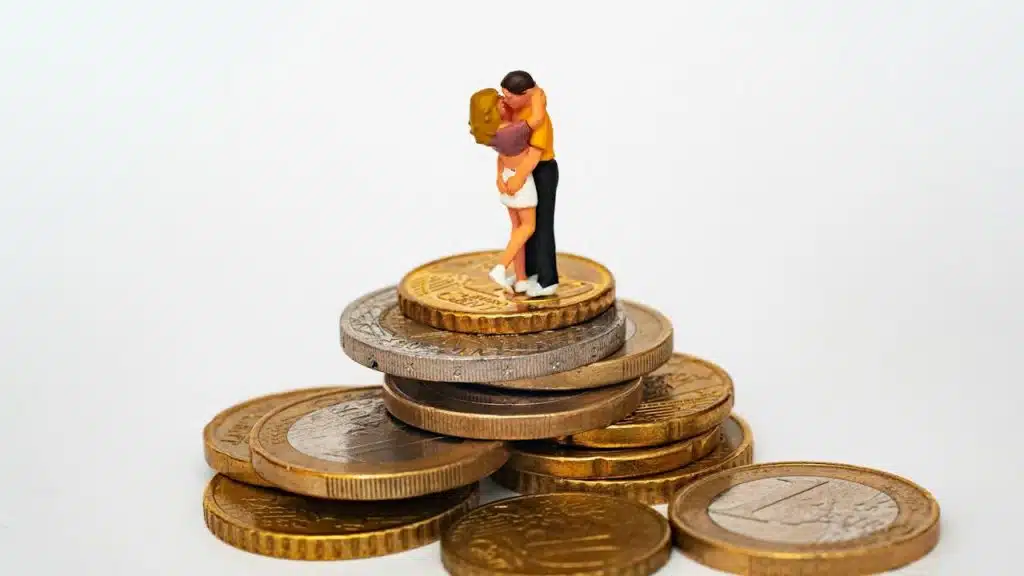A figurine of a man and woman hugging on coins.