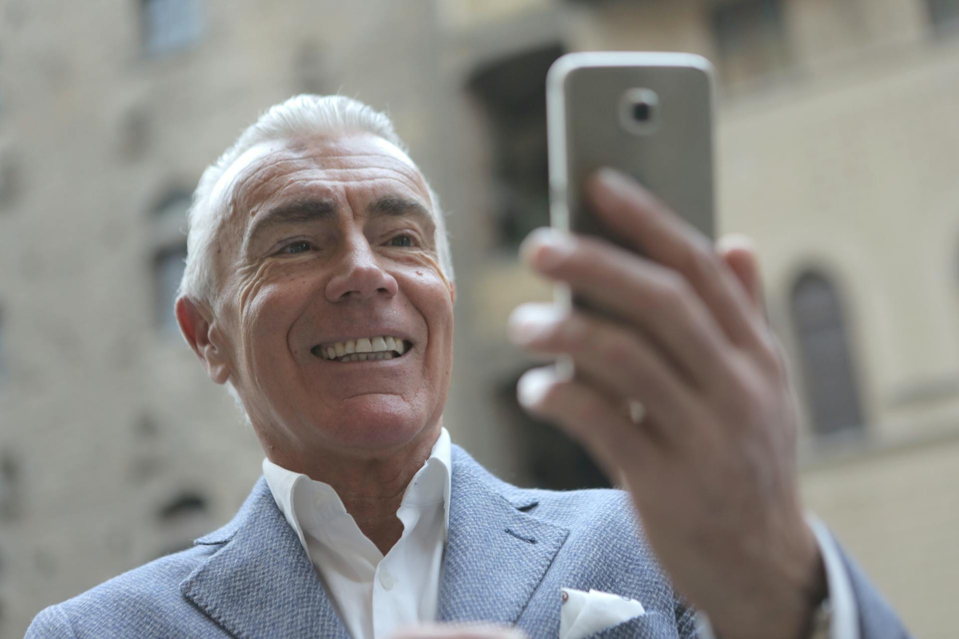 An elderly man taking a selfie.