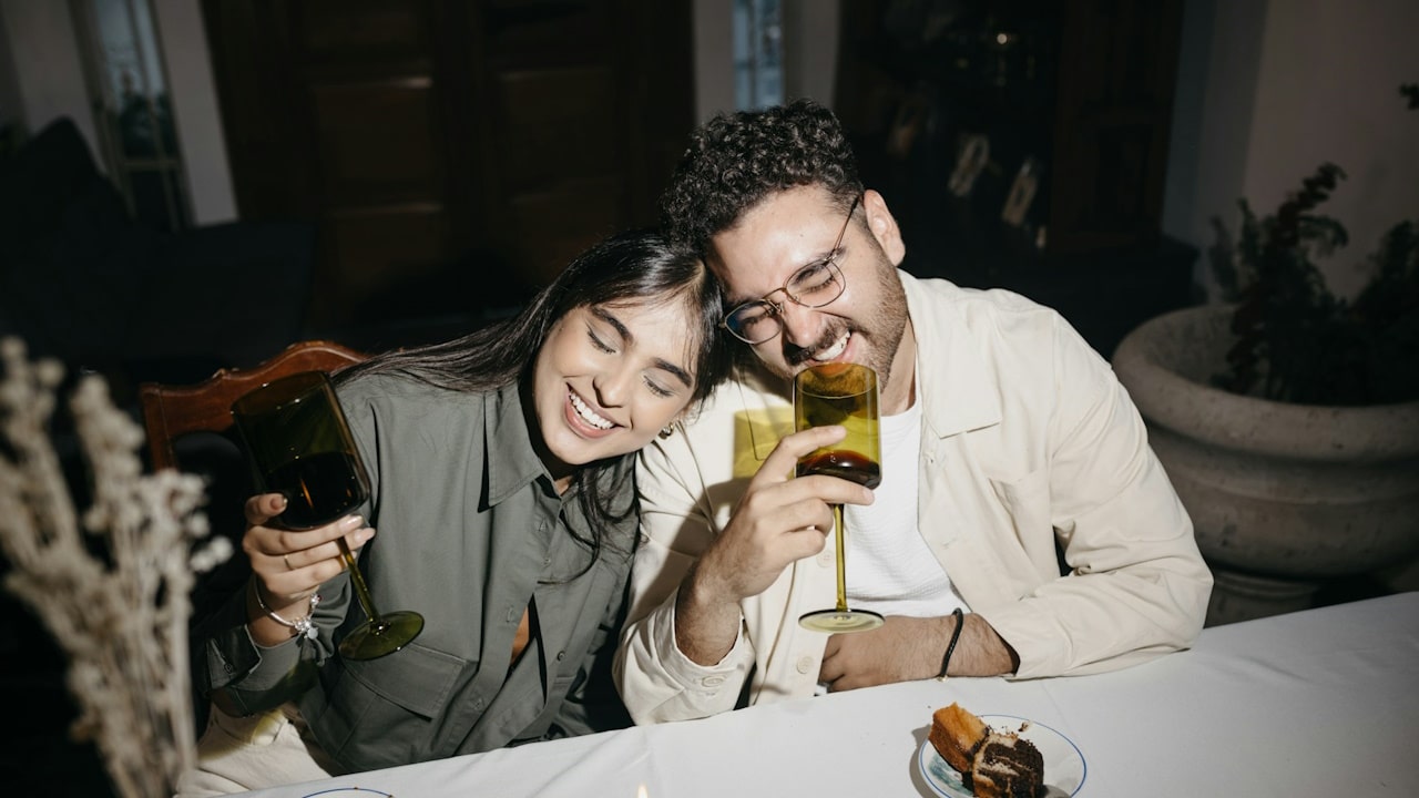 A man and a woman drinking wine at a table.