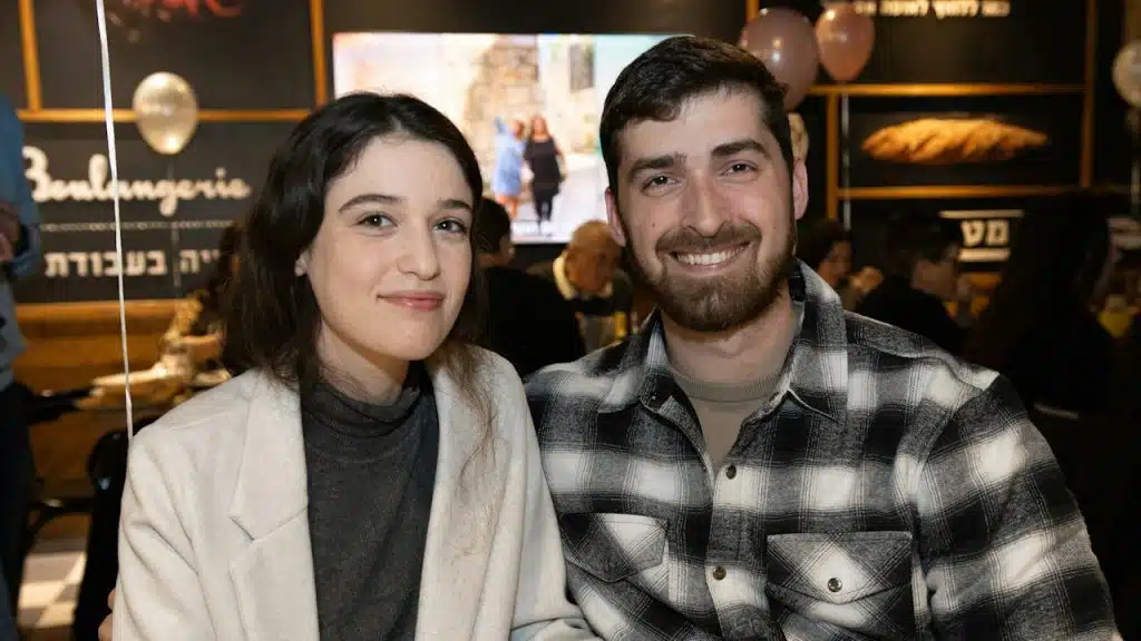 A man and a woman sitting next to each other in a restaurant.
