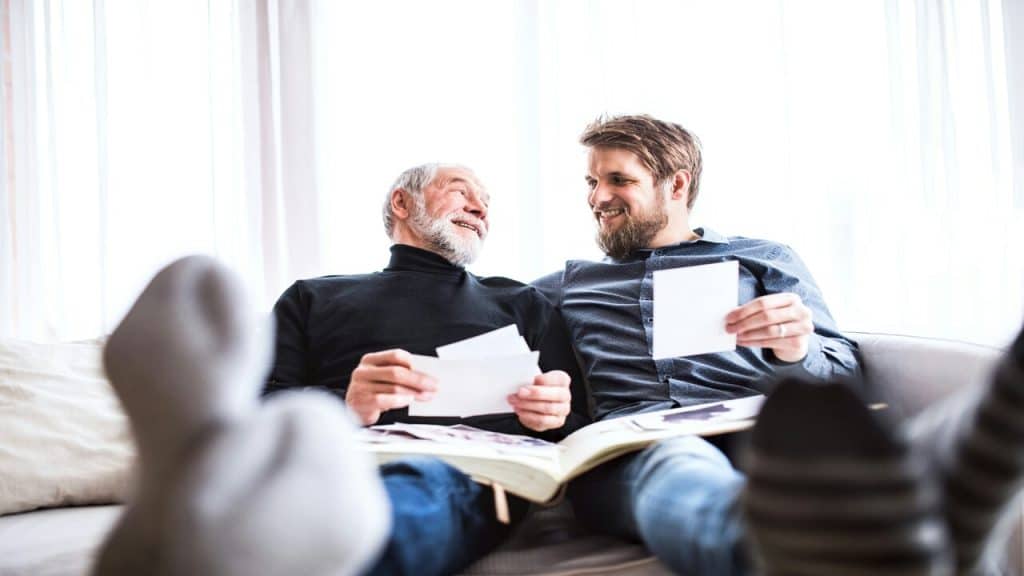 A man looking at photo albums with his son