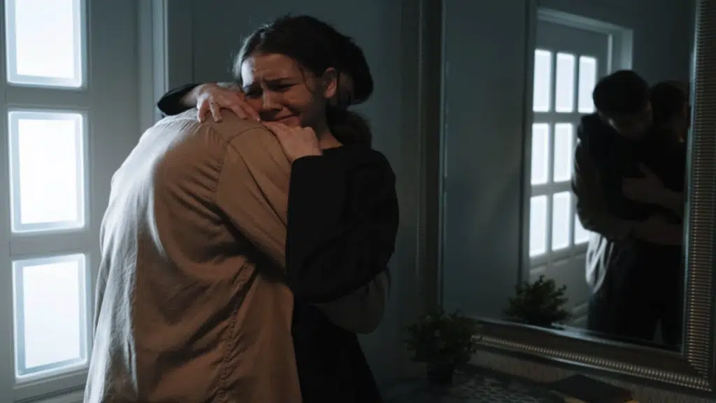 A man hugging his crying wife