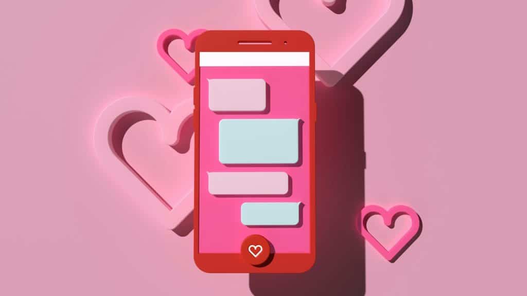 A pink cell phone with hearts on a pink background.