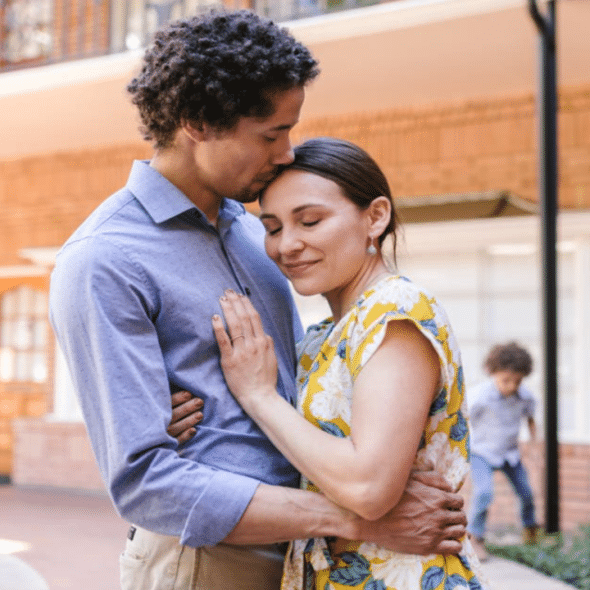A man giving his wife a forehead kiss