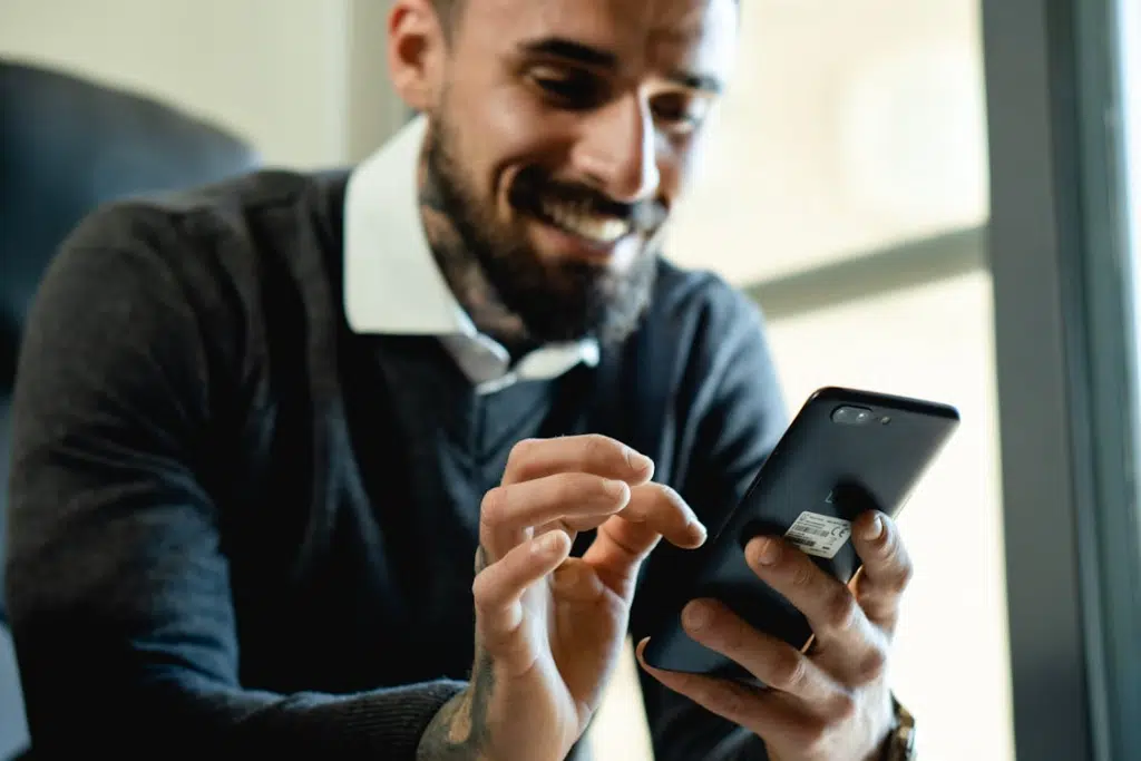A man texting while smiling