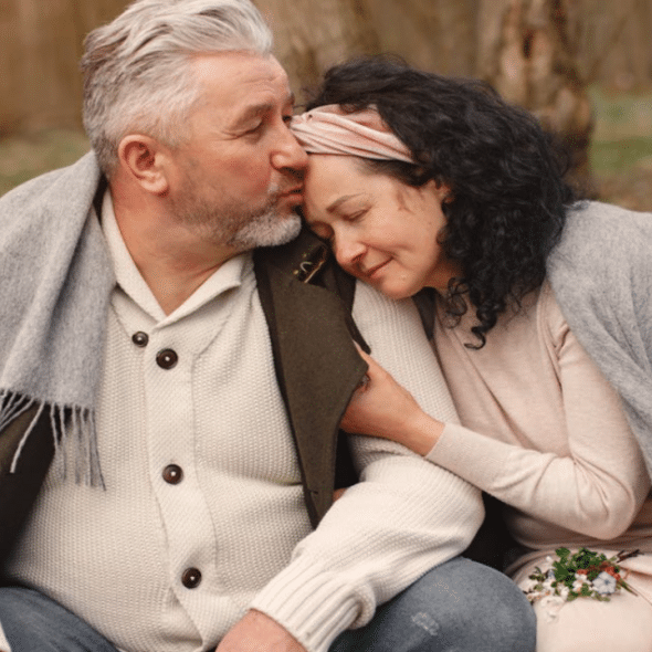 A man giving his wife a forehead kiss