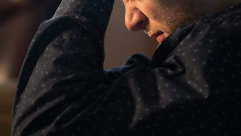 A man holding his head with a stressed expression.