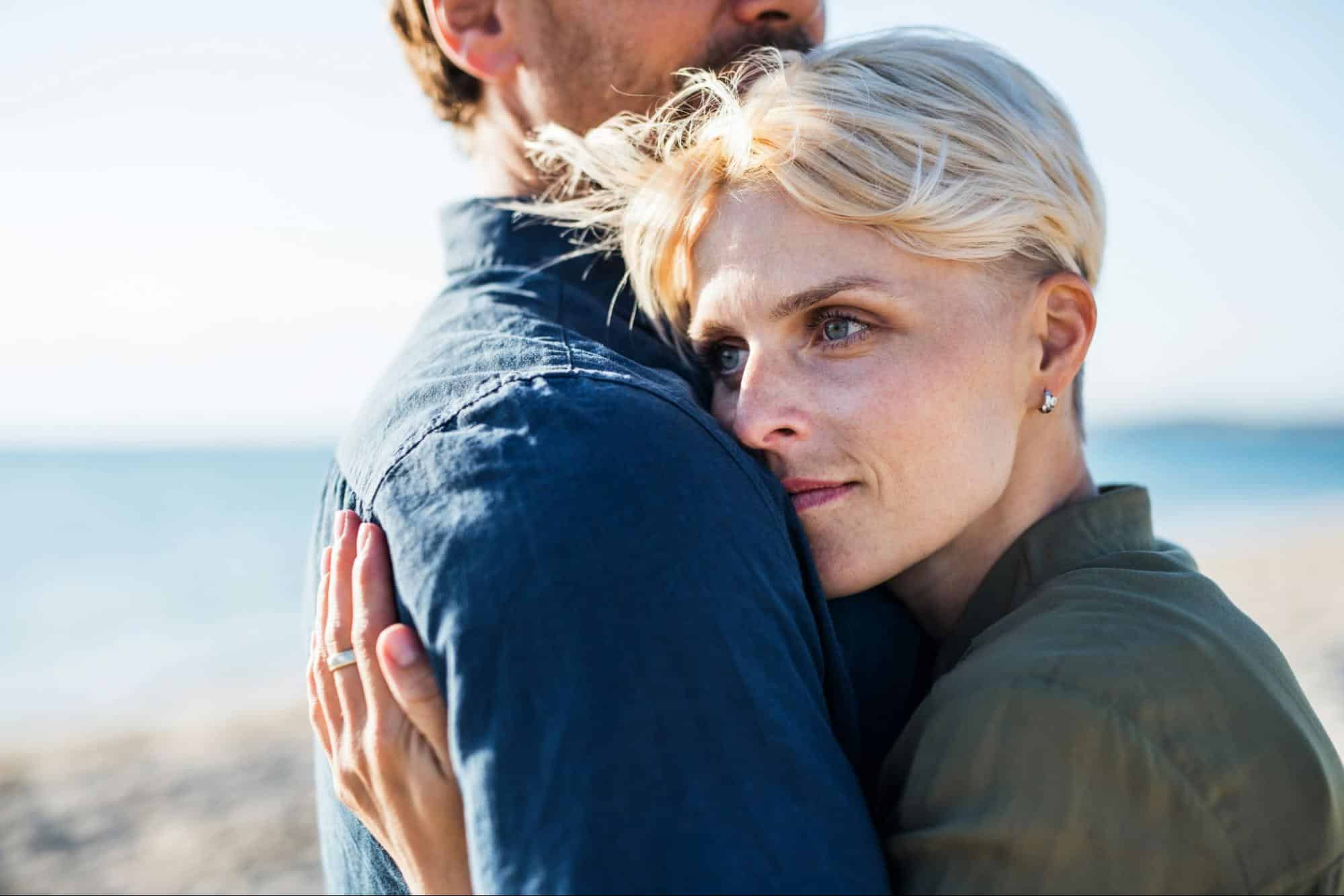 A woman hugging a man tightly