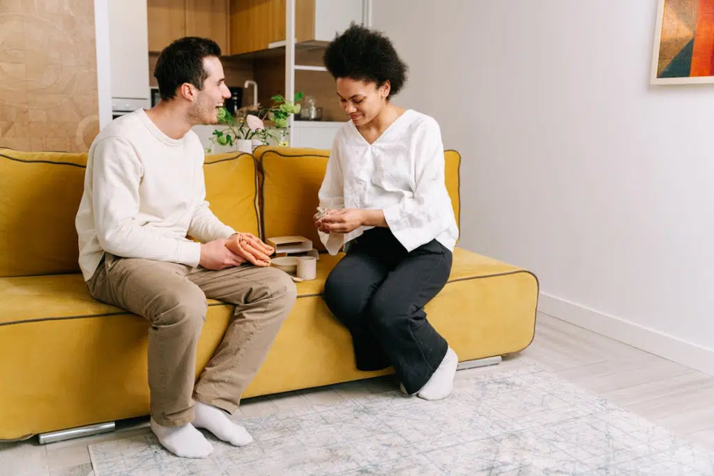 An man and woman sitting on a yellow couch