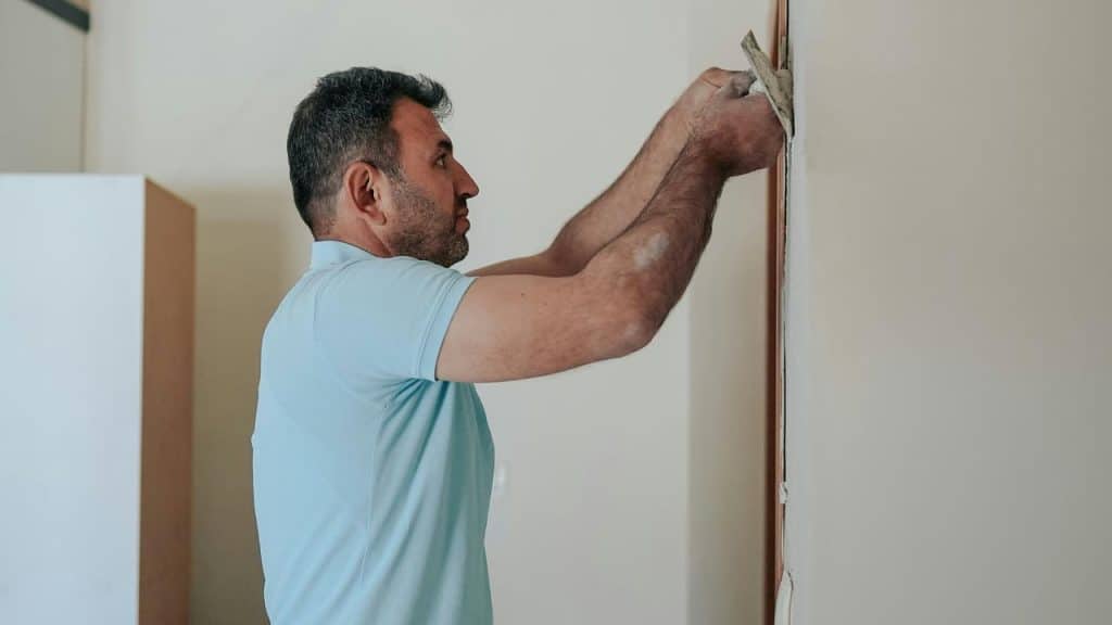 A person smoothing plaster on a wall.