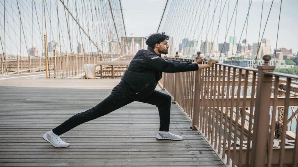 A man stretching on a bridge