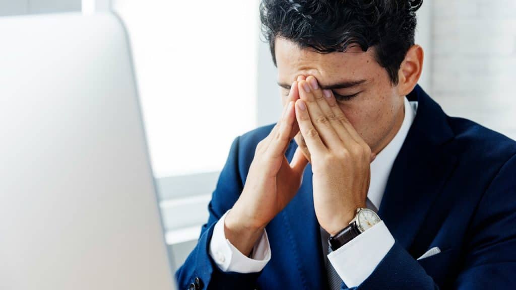 A tired man holding his head with his hands.