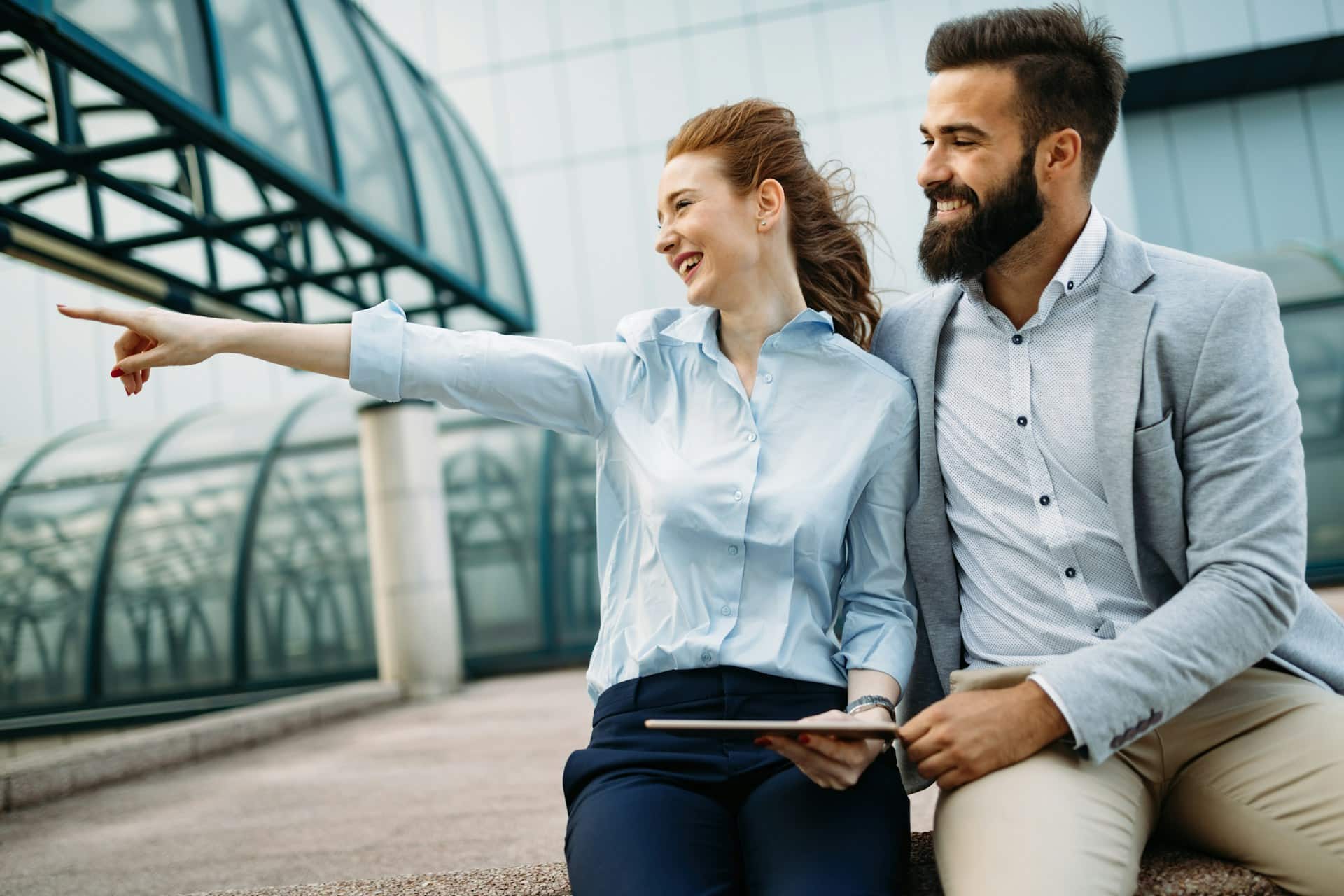 A man and a woman looking at something outside.