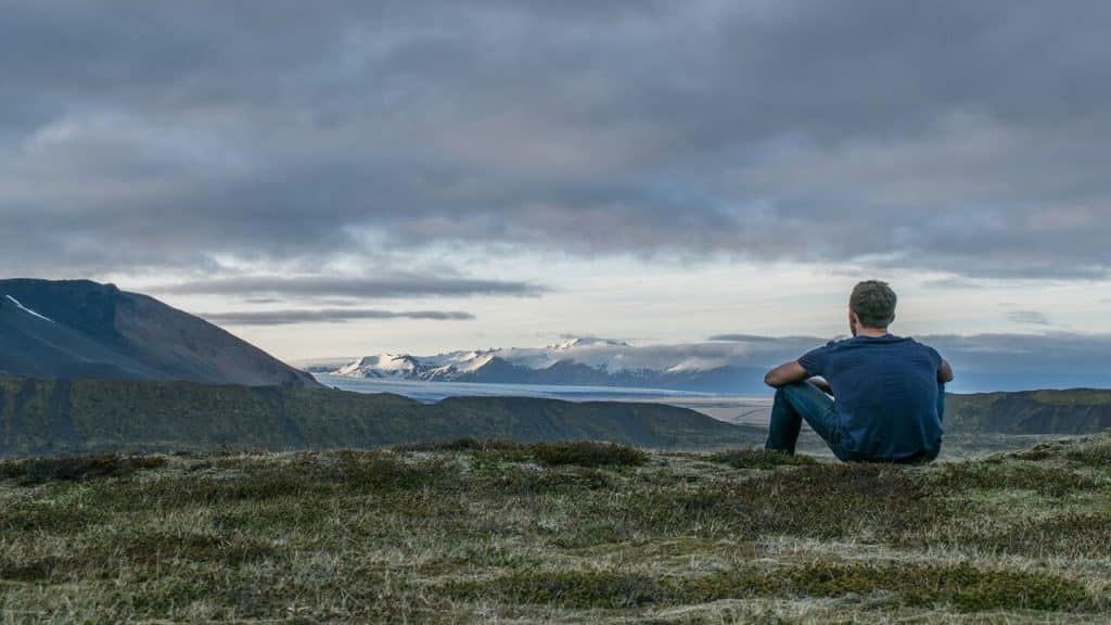 A man sitting alone on a mountain