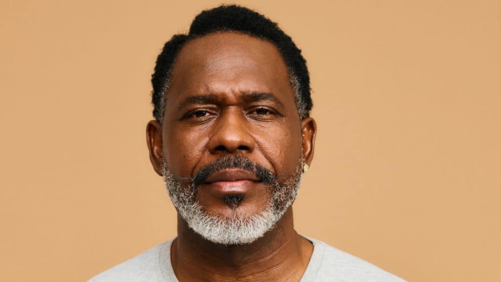 A mature bearded man looking at the camera with a serious expression.