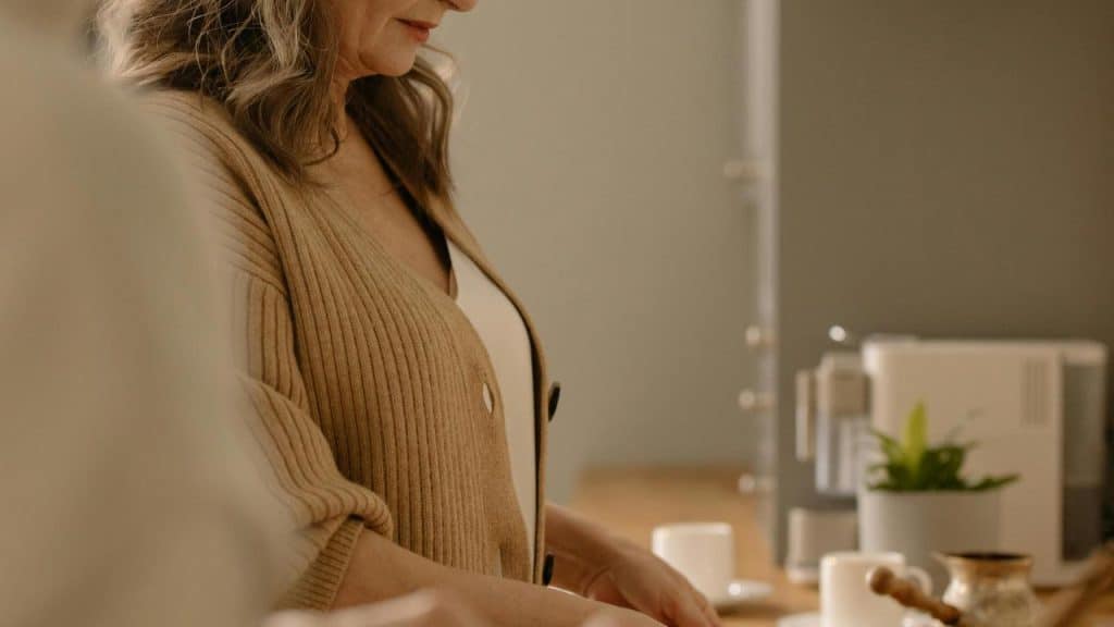 A woman standing in a kitchen preparing something on the counter.