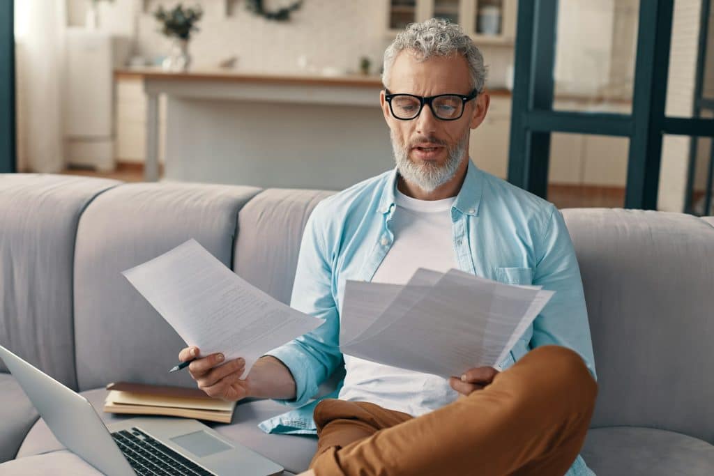 A man reading documents at home.