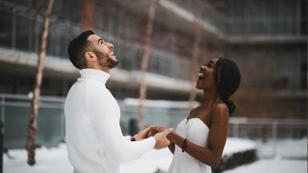 A man and a woman holding hands and hugging each other.