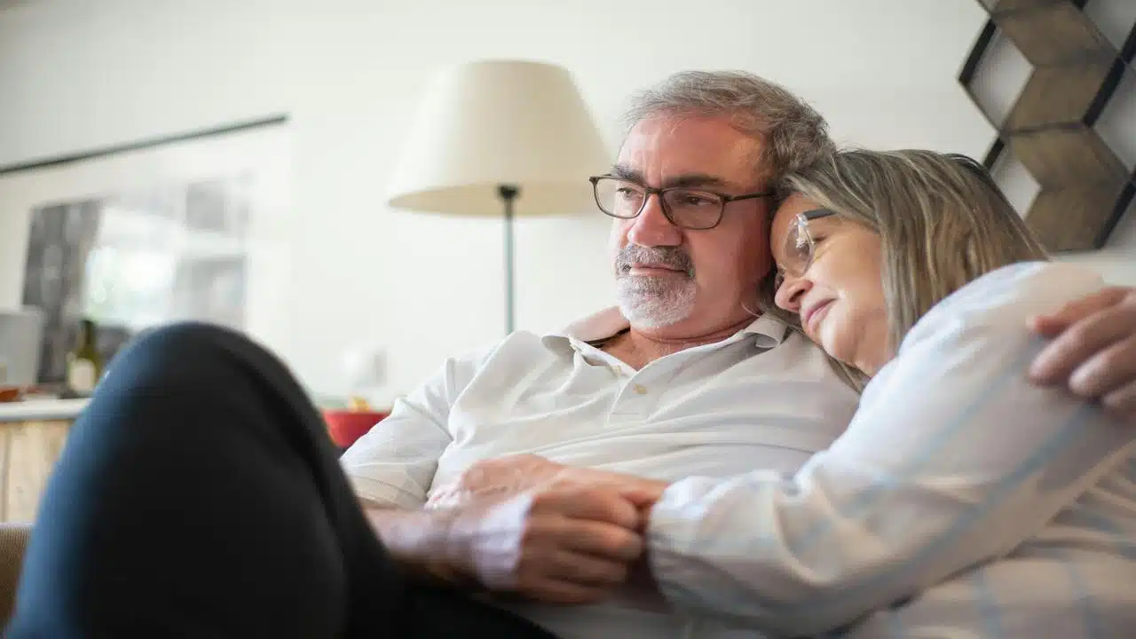 A mature couple cuddling on the couch