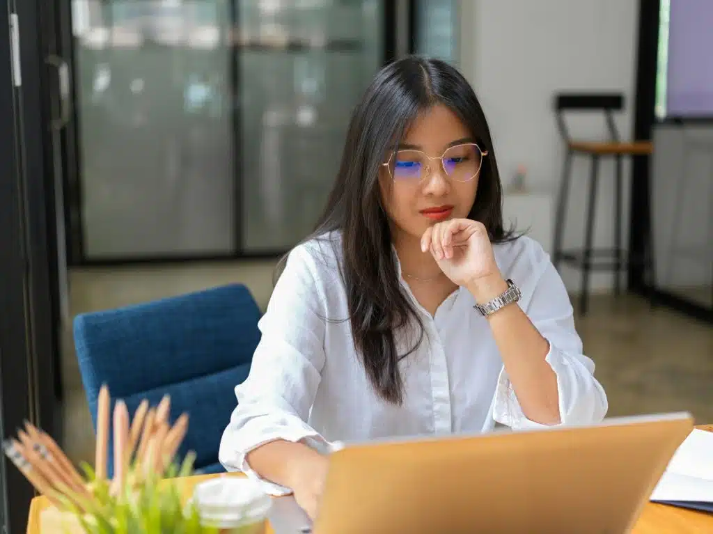 A woman concentrating on her work with a laptop.