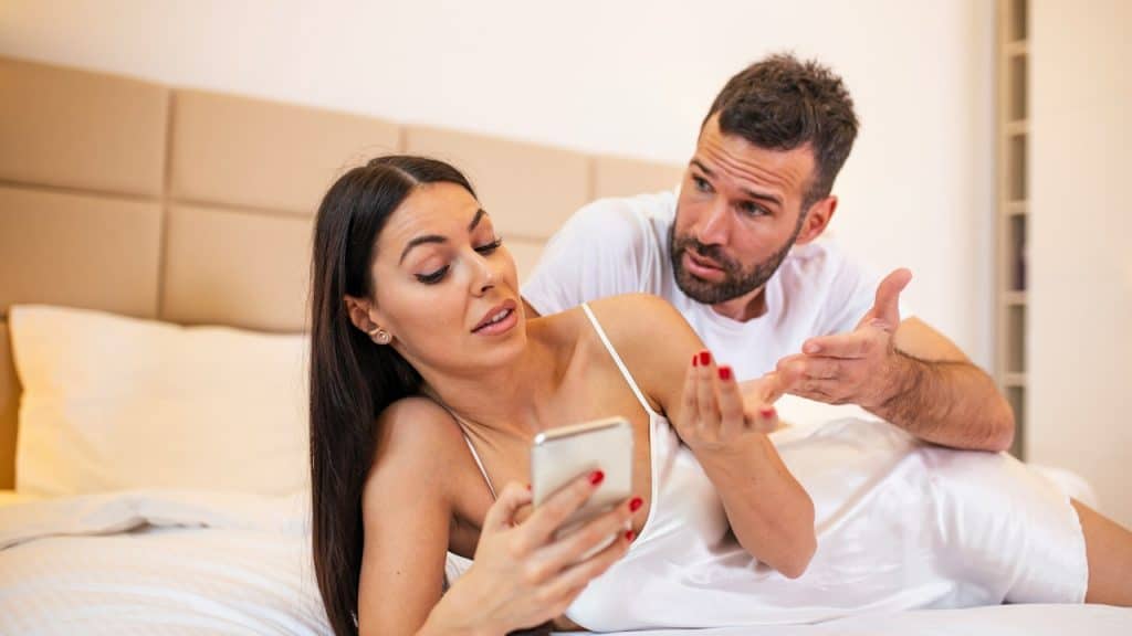 A man is inquiring of his wife about the call coming on her phone.