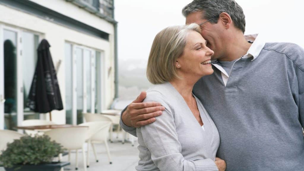 A mature couple hugging outdoors