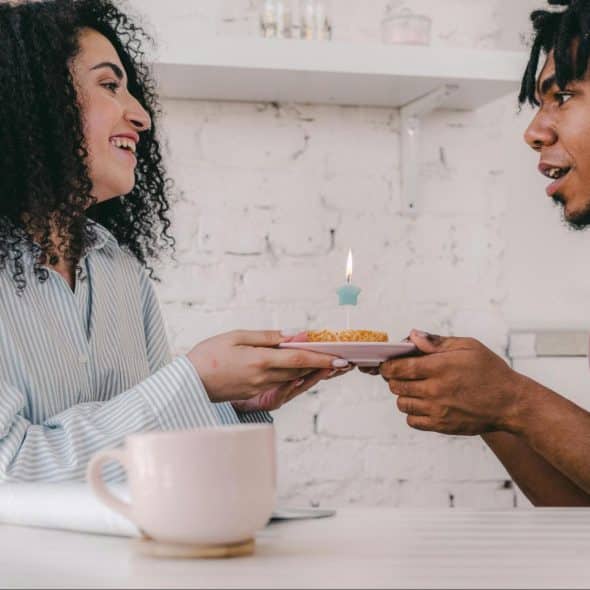 A man giving a cupcake to woman