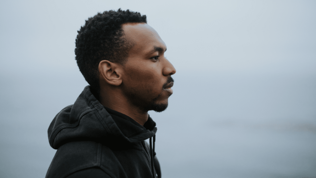 A man looking serious while watching the water