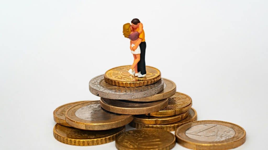A figurine of a man and woman hugging on coins.