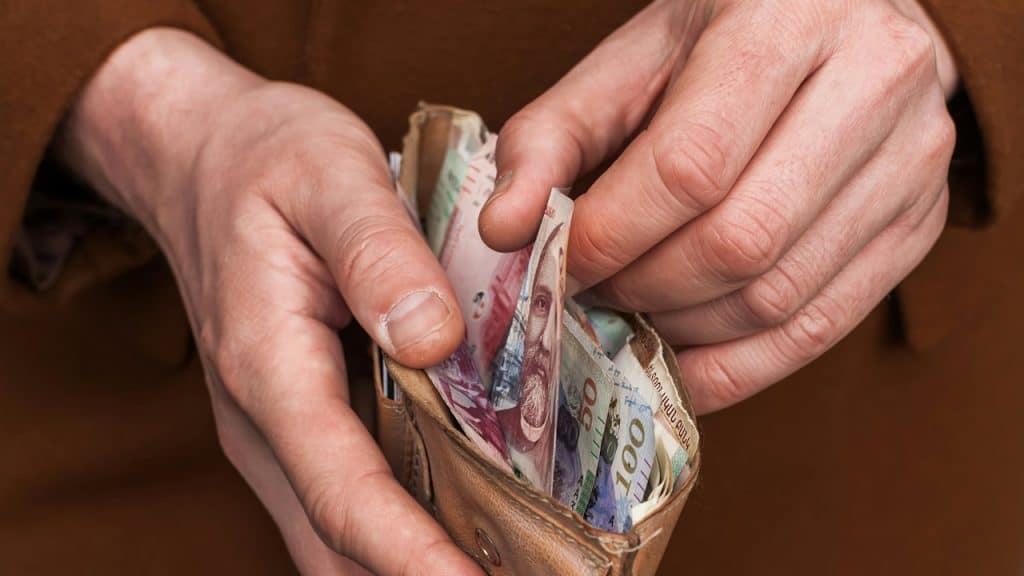 A person holding a wallet full of money.