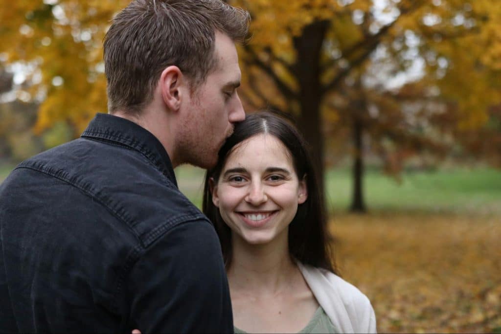 A man kissing a woman’s head