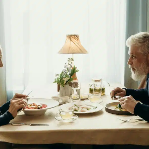 An elderly couple having a meal together.