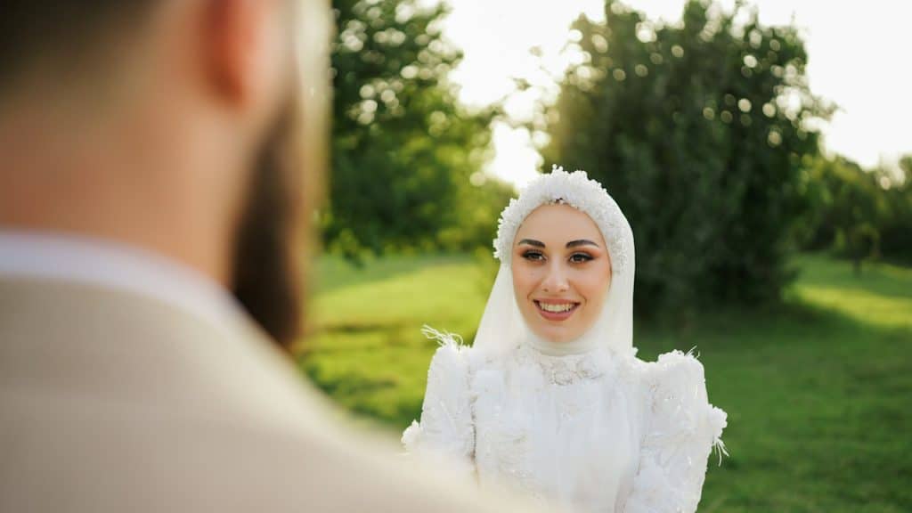 A woman in a white dress standing in front of a man.