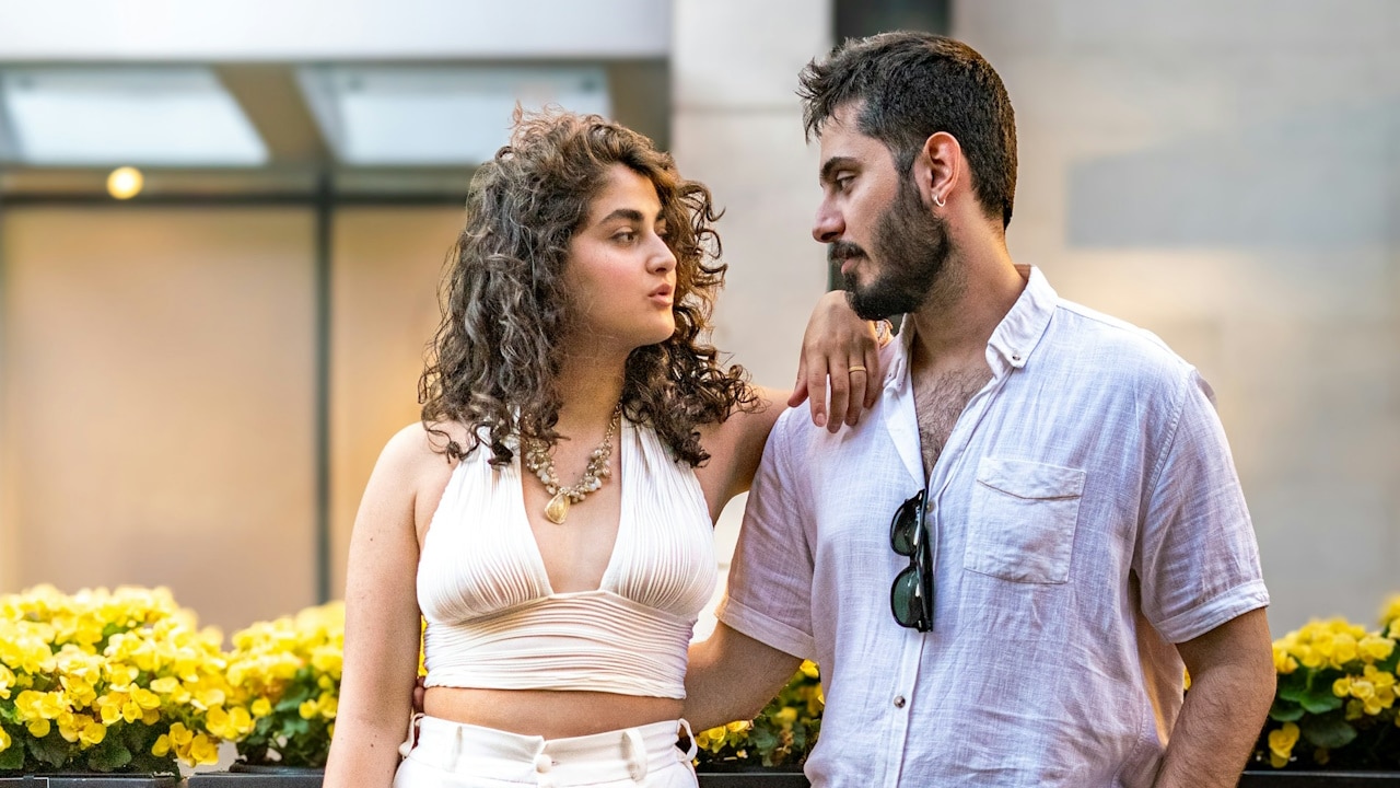 A couple looking at each other while posing for a picture.
