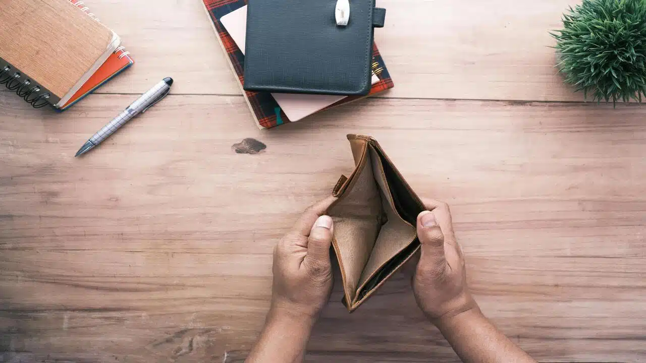 A man looking at his empty wallet