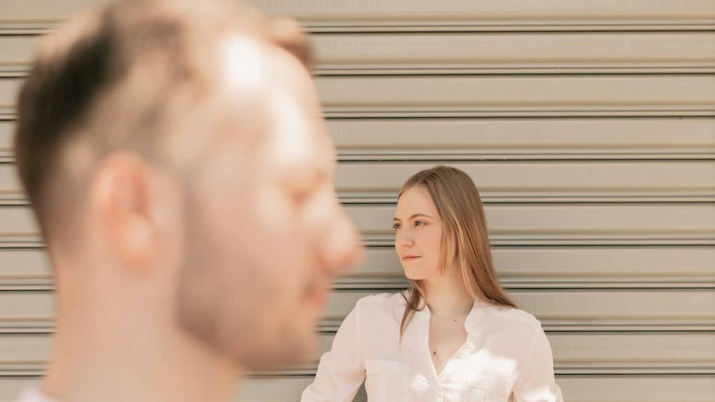 A couple standing in front of a garage door.