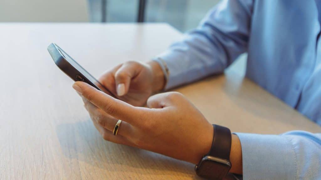 A person using a smartphone at a table.